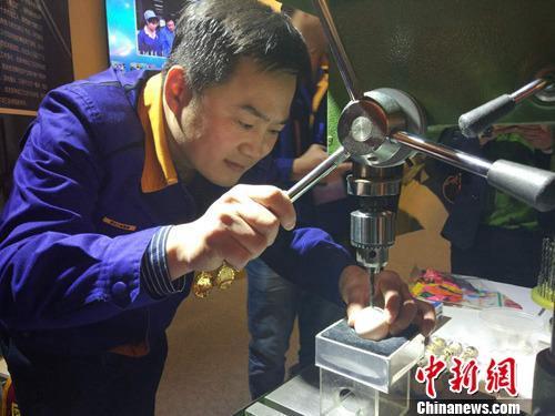 大国工匠张新停表演电钻钻鸡蛋绝活。<a target='_blank' data-cke-saved-href='http://www.chinanews.com/' href='http://www.chinanews.com/' >中新网</a>记者 李金磊 摄