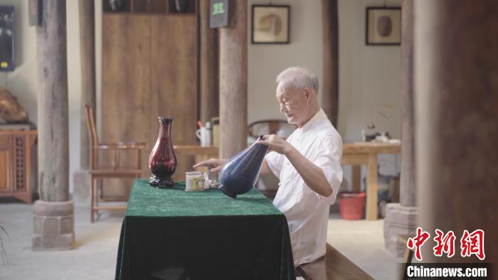 图为丁国坤对一件脱胎漆器进行最后一道工序搽青。 李剑波 摄