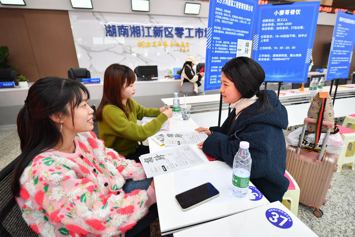 在湖南湘江新区零工市场,求职者(右)向工作人员咨询岗位信息(2024年3月20日摄)。 新华社记者 陈泽国 摄