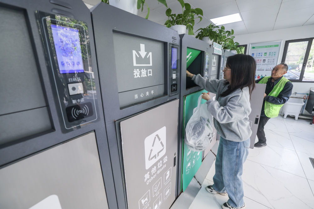在浙江省湖州市吴兴区飞英街道新华府小区内,居民在进行垃圾分类投放(2024年4月10日摄)。新华社记者 徐昱 摄