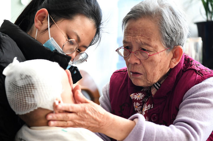 2022年11月16日,在陕西省榆林市佳县,路生梅(右)在家中为患儿义诊。 新华社发(邹竞一 摄)