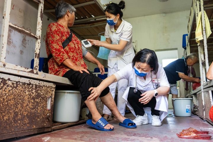 2024年7月30日,在湖南省湘潭县河口中学安置点,医务人员为受洪水影响而转移安置的群众检查身体。 新华社记者 陈思汗 摄