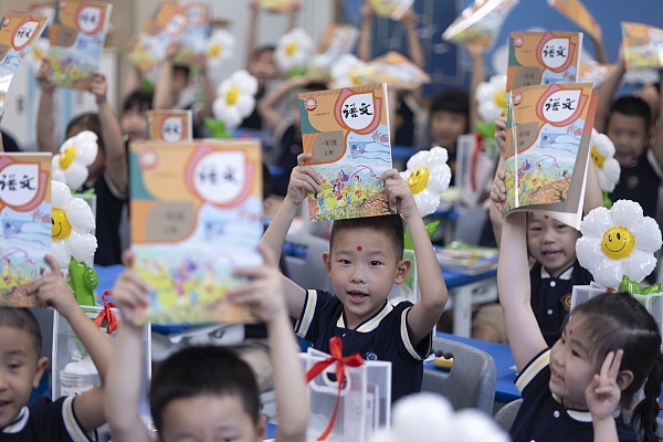 △学生喜领新课本 迎接新学期第一课