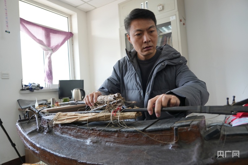 翟俊正展示其高祖制作的“邦摇”船模(央广网记者 周思杨 摄)
