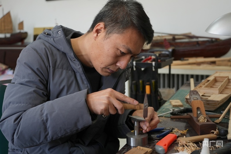 翟俊正在制作船模(央广网记者 周思杨 摄)